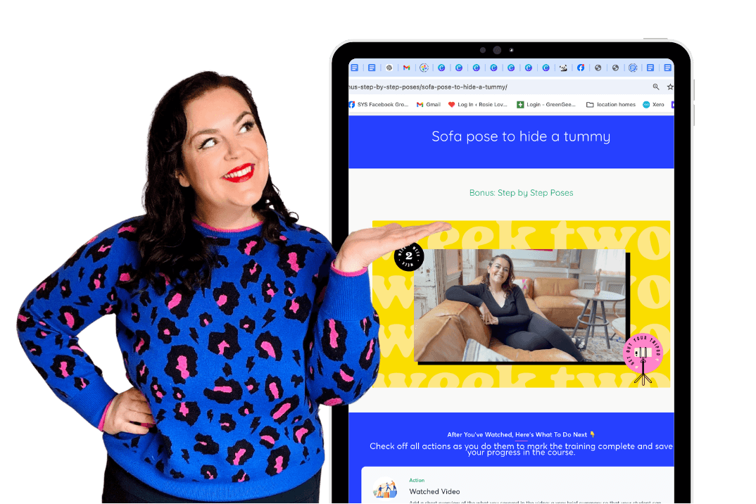 Woman in a blue sweater with pink leopard print standing next to a tablet displaying a website.