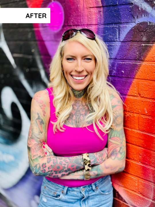 Lea Turner, a business community founder with tattoos leans against a coluorful graffiti wall for a selfie created with the slay your selfies method